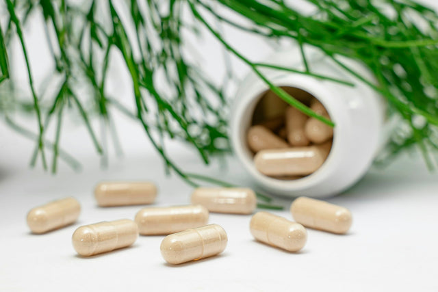 Capsules bij een omgevallen potje met groene grassprieten